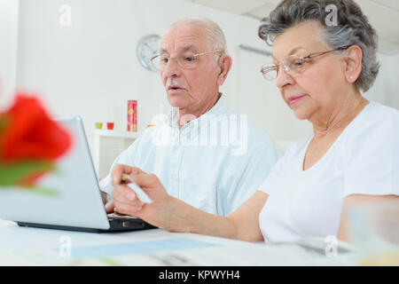 Ältere Menschen Paar am Computer, Frau hält Kreditkarte Stockfoto