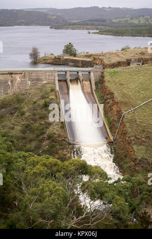 Konkrete Bogenstaumauer mit Wasser Auslaufen der Ski-springen Abflußkanal durch einen sehr vollen Behälter am Stausee in Myponga Myponga, Süd Australien gesichert. Stockfoto