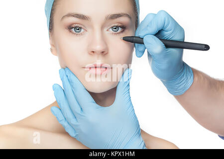 Schöne junge Frau mit Perforationslinien auf ihrem Gesicht vor Operation plastische Chirurgie. Stockfoto