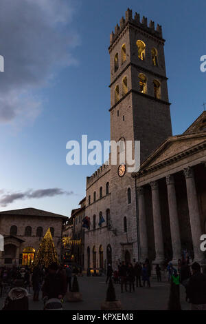 Piazza del Comune (Assisi, Umbrien), während der Weihnachtszeit, mit beleuchtetem Baum in der Nähe der Glockenturm und Minerva Tempel, und Passanten Stockfoto