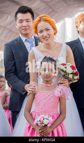 Colombo, Sri Lanka. 17. Dezember, 2017. Eine chinesische Braut posiert für ein Foto mit einer Sri Lankan Flower Girl während einer Messe Hochzeit in Colombo, Sri Lanka Credit: vimukthi Embuldeniya/Alamy leben Nachrichten Stockfoto