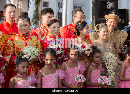 Colombo, Sri Lanka. 17. Dezember, 2017. Eine chinesische Braut posiert für ein Foto mit einer Sri Lankan Flower Girl während einer Messe Hochzeit in Colombo, Sri Lanka Credit: vimukthi Embuldeniya/Alamy leben Nachrichten Stockfoto