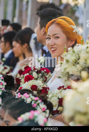 Colombo, Sri Lanka. 17. Dezember, 2017. Eine chinesische Braut posiert für ein Foto mit einer Sri Lankan Flower Girl während einer Messe Hochzeit in Colombo, Sri Lanka Credit: vimukthi Embuldeniya/Alamy leben Nachrichten Stockfoto