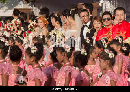 Colombo, Sri Lanka. 17. Dezember, 2017. Eine chinesische Braut posiert für ein Foto mit einer Sri Lankan Flower Girl während einer Messe Hochzeit in Colombo, Sri Lanka Credit: vimukthi Embuldeniya/Alamy leben Nachrichten Stockfoto