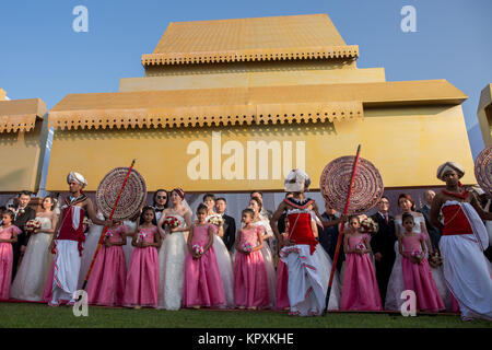 Colombo, Sri Lanka. 17. Dezember, 2017. Ein chinesisches Paar posiert für ein Foto mit einer Sri Lankan Flower Girl während einer Messe Hochzeit in Colombo. 50 Chinesische Paare waren eine Zeremonie in der Hauptstadt Sri Lankas heiratete der 60. Jahrestag der Aufnahme der diplomatischen Beziehungen zwischen den beiden Ländern zu markieren. Credit: vimukthi Embuldeniya/Alamy leben Nachrichten Stockfoto