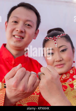 Colombo, Sri Lanka. 17. Dezember, 2017. Ein chinesisches Paar posiert für ein Foto mit einer Sri Lankan Flower Girl während einer Messe Hochzeit in Colombo. 50 Chinesische Paare waren eine Zeremonie in der Hauptstadt Sri Lankas heiratete der 60. Jahrestag der Aufnahme der diplomatischen Beziehungen zwischen den beiden Ländern zu markieren. Credit: vimukthi Embuldeniya/Alamy leben Nachrichten Stockfoto