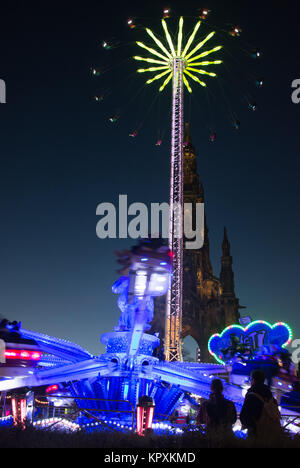 Edinburgh, Großbritannien. 16. Dezember 2017 in Edinburgh ist Weihnachten in der Innenstadt mit den wichtigsten Sehenswürdigkeiten rund um die Princes Street Gardens statt. Unbekannter Teilnehmer zusehen, wie das Scott Monument hinter den Sehenswürdigkeiten liegt. Credit: George Philip/Alamy leben Nachrichten Stockfoto