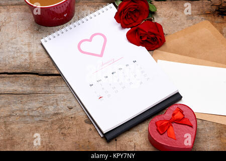 Kalender das Datum 14. Februar. Red Rose, Herzen und Geschenkbox auf hölzernen Tisch. Stockfoto