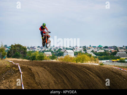 Der Racer auf einem Motorrad nimmt an einem motocross Rennen, hebt ab und springt auf einem Hügel. Close-up. Stockfoto