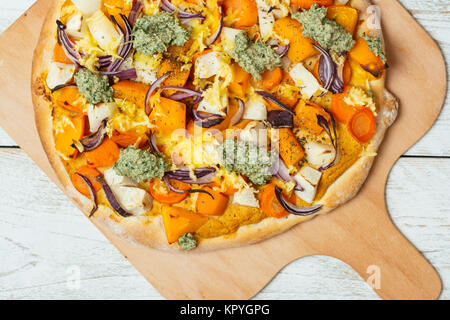 Hausgemachte Pizza mit Winter Squash, Pastinaken, schwarzem Rettich, roten Zwiebeln, veganer Käse und Rettich grünen Pesto. Stockfoto