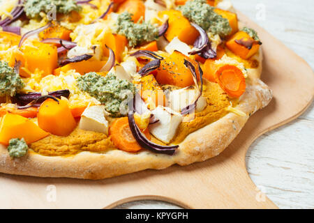 Hausgemachte Pizza mit Winter Squash, Pastinaken, schwarzem Rettich, roten Zwiebeln, veganer Käse und Rettich grünen Pesto. Stockfoto