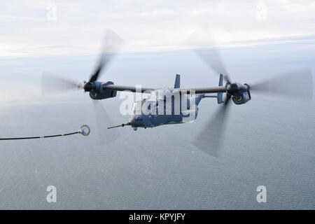 Air Commandos mit der 7 Special Operations Squadron, 352 d Special Operations Wing Tilt rotor Luft durchführen, um die Luftbetankung (TAAR) zwischen einem CV-22 Osprey und ein MC-130J Commando II während einer Fähigkeit, zu überleben und zu betreiben (Atso) Übung in dem Flieger Notfallmaßnahmen für chemische Kriegsführung 13. Dez., 2017 praktiziert, RAF Mildenhall. Stockfoto