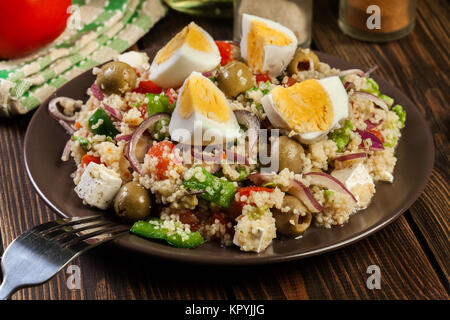 Frischer Salat mit Couscous, Eiern, Paprika, roten Zwiebeln, Schafskäse und Olivenöl. Östliche Küche. Stockfoto