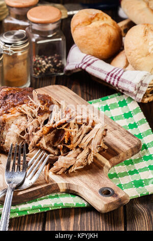 Langsam zog gekochte Schweineschulter auf Schneidebrett. Stockfoto