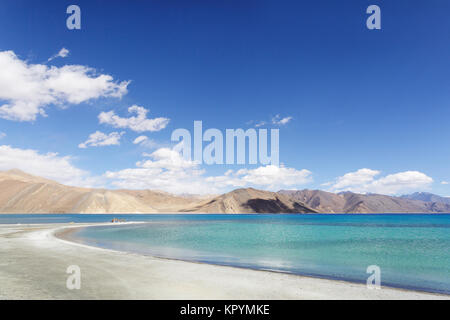 Gebetsfahnen am weißen Sandstrand mit einer kleinen sandigen Halbinsel an die herrliche Landschaft an Pangong Tso See, Ladakh, Jammu und Kaschmir, Indien. Stockfoto