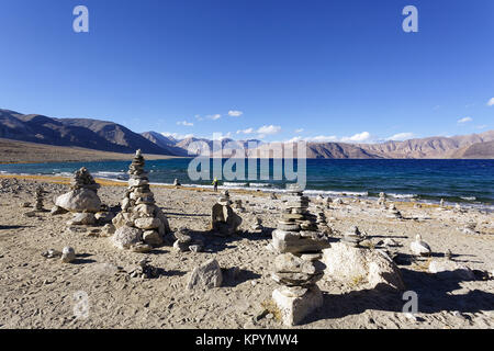 Junge kaukasier Junge spielt in Stein Türme von der Pangong Tso See in windigen Bedingungen, Ladakh, Jammu und Kaschmir, Indien. Stockfoto