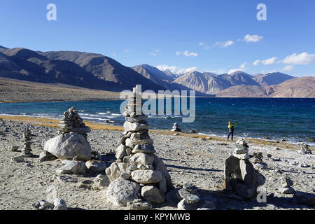 Junge kaukasier Junge spielt in Stein Türme von der Pangong Tso See in windigen Bedingungen, Ladakh, Jammu und Kaschmir, Indien. Stockfoto