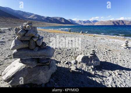 Junge kaukasier Junge spielt in Stein Türme von der Pangong Tso See in windigen Bedingungen, Ladakh, Jammu und Kaschmir, Indien. Stockfoto