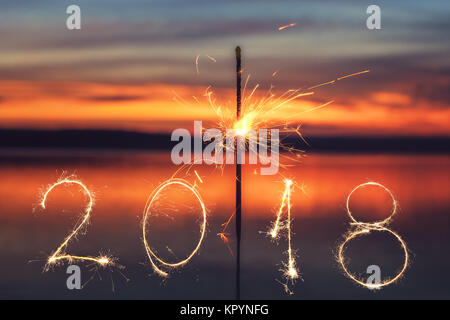 2018 mit Schein Feuerwerk auf dem Sunset Hintergrund geschrieben, glückliches neues Jahr 2018. Stockfoto