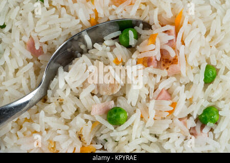 Mahlzeit Hintergrund. Orientalisches Reisgericht mit Fleisch, gekochtem Ei, frisches Gemüse wie Erbsen und Karotten. Löffel und traditionellen thailändischen Speisen. Stockfoto