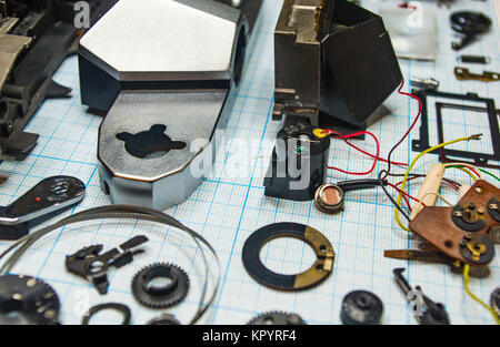 Teile sind vollständig demontiert alten retro Film SLR Kamera auf Millimeterpapier, close-up Stockfoto