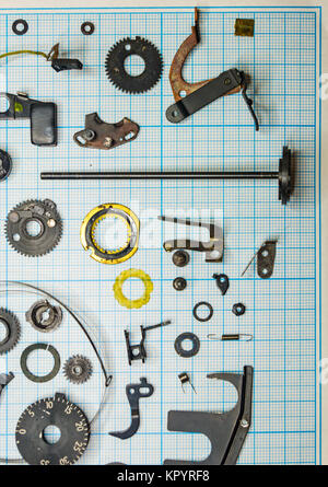 Teile sind vollständig demontiert alten retro Film SLR Kamera auf Millimeterpapier, close-up Stockfoto