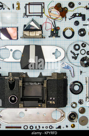 Teile sind vollständig demontiert alten retro Film SLR Kamera auf Millimeterpapier, close-up Stockfoto