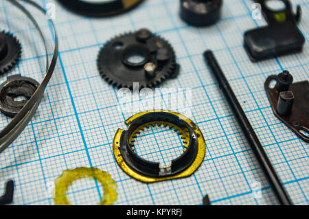 Teile sind vollständig demontiert alten retro Film SLR Kamera auf Millimeterpapier, close-up Stockfoto