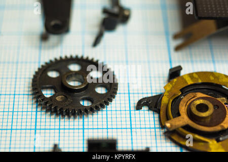 Teile sind vollständig demontiert alten retro Film SLR Kamera auf Millimeterpapier, close-up Stockfoto