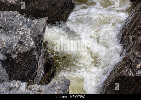 Wasserfall fließt zwischen den Lavasteinen Stockfoto