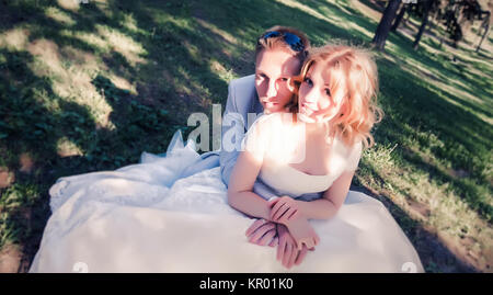 Hochzeit paar sitzen auf der Wiese im Wald Stockfoto