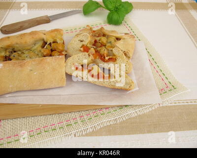 Hand Brot gefüllt mit Kichererbsen, Tomaten und Käse Stockfoto