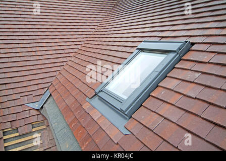 Work in progress Typ auf Velux Dachfenster & Dachziegel mit Tal Dachrinne auf ein normales Ziegeldach für neue Einfamilienhaus Essex England Großbritannien Stockfoto