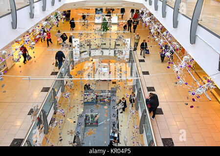 Blick aus der Vogelperspektive von oben auf den Korridor und zwei Ebenen von Einkaufszentren Shopping-Etagen Käufer Weihnachtsdekorationen Essex England UK Stockfoto