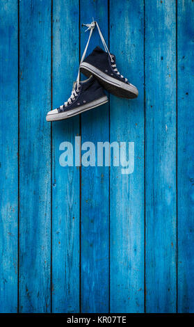 Paar blaue Turnschuhe an eine Holzwand Stockfoto