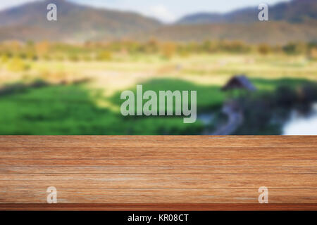 Tischplatte aus Holz mit grünem Reis Bereich unscharfer Hintergrund Stockfoto