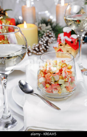 Salat von Cubes von krabben Fleisch und Gemüse mit Joghurt im Glas auf der Weihnachten Tabelle gekleidet Stockfoto