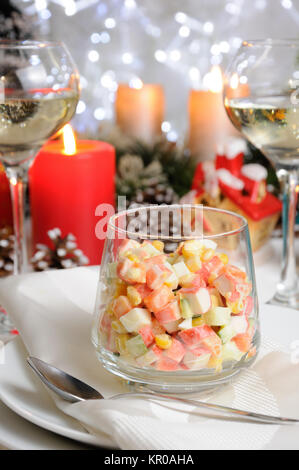 Salat von Cubes von krabben Fleisch und Gemüse mit Joghurt im Glas auf der Weihnachten Tabelle gekleidet Stockfoto