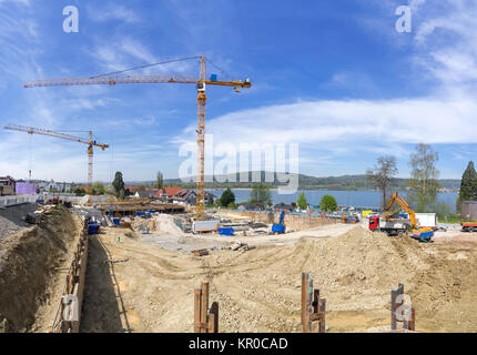 Grosse Baustelle mit zwei Kränen an einem See. Stockfoto