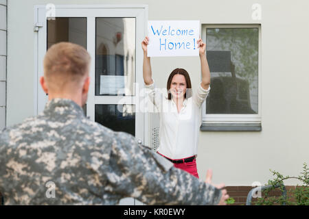 Frau einladend Ihren Ehemann Home Stockfoto