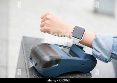 Weibliche Kunden zahlen über Smart Watch Stockfoto