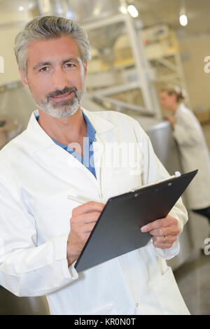 Mann in weißen Jacke hält Zwischenablage Stockfoto