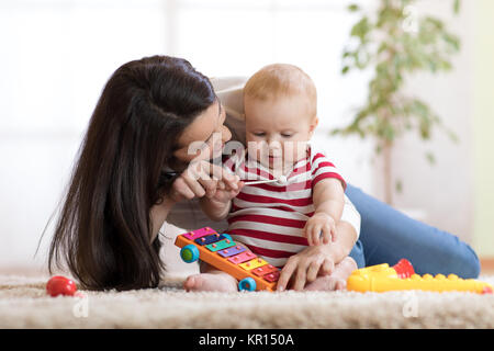 süße Mutter und Kind junge spielen zusammen im Haus zu Hause Stockfoto