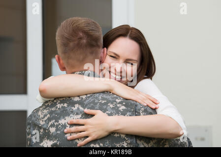 Glückliche Ehefrau umarmte ihren Mann Stockfoto