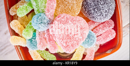 Overhead Nahaufnahme von gum Drops und Gummibärchen Wurm candy im Orange Bowl alle in Puderzucker abgedeckt Stockfoto