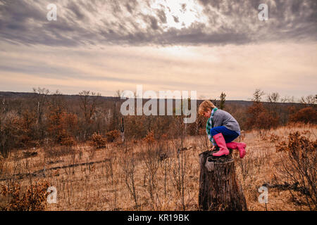 Junge klettern auf einen Baum alter Baumstumpf Stockfoto