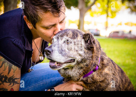 Frau im Park küsst ihren Pitbull Hund, Sankt Petersburg, Florida, USA Stockfoto