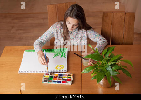 Mädchen sitzen an einem Tisch, Malerei Stockfoto