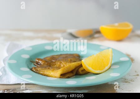 Crepe Suzette in Karamell Sauce auf einer Platte mit einer Scheibe Orange, französischer Nachtisch. Selektive konzentrieren. Stockfoto