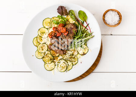 Steak mit Zucchini gratin Stockfoto